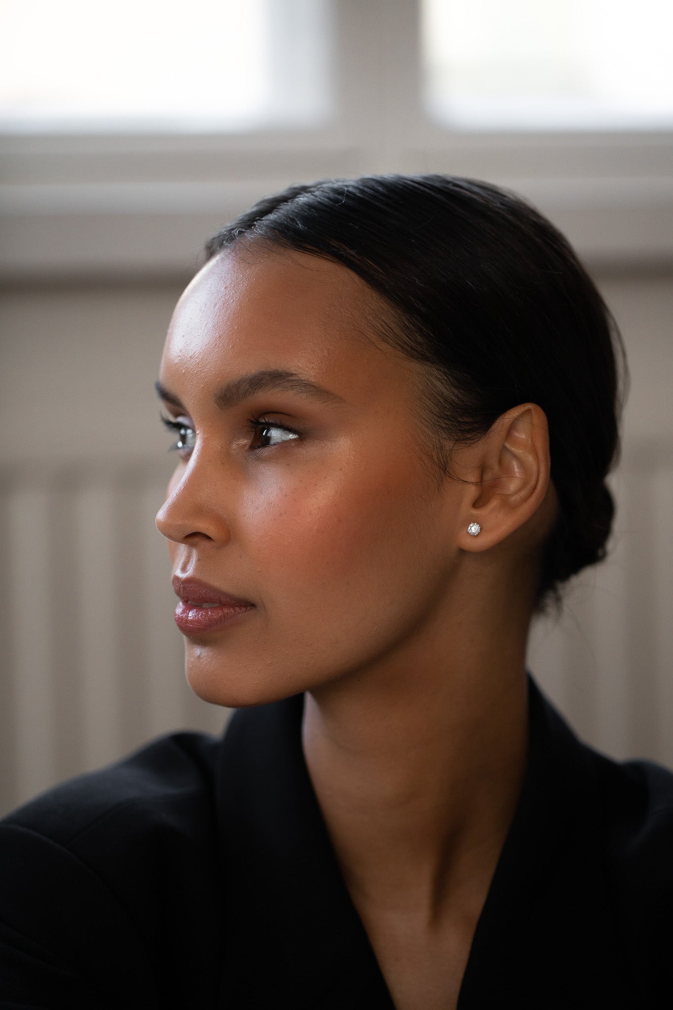 Elegant and stylish woman wearing Round Diamond Studs, made of sustainable lab-grown diamonds and 18k solid gold.