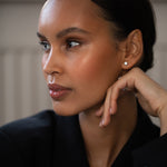 Elegant woman wearing Diamond Studs, made of round-cut lab-grown diamonds and 18k solid gold.