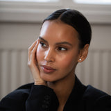Elegant and stylish woman wearing Round Diamond Studs, made of sustainable lab-grown diamonds and 18k solid gold.