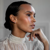 Elegant Scandinavian woman wearing Pear Drop Diamond Studs, made of sustainable lab-grown diamonds and 18k solid gold.