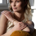 Elegant woman wearing sustainable Diamond Station Bracelet that is made of ethical lab-grown diamonds and recycled solid gold.