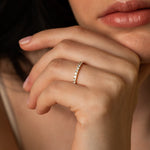 A close-up lifestyle shot focusing on a model resting her hand near her face, beautifully showcasing the bold silhouette of the Pavé Diamond Ring III in 18k white gold.