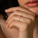 A close-up lifestyle shot focusing on a model resting her hand near her face, beautifully showcasing the bold silhouette of the Pavé Diamond Ring III in 18k white gold.