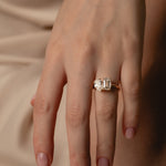 Emerald and Pear Toi et Moi two-stone diamond ring in yellow gold on a model's hand, top view