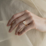 A KARAAT Emerald Trilogy diamond engagement ring in 18k rose gold styled with a delicate organza dress.