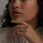 A KARAAT Emerald Trilogy ring in 18k rose gold worn by a model, providing contemporary bridal inspiration.
