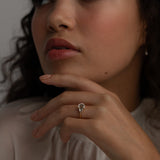 A KARAAT Emerald Trilogy ring in 18k rose gold worn by a model, providing contemporary bridal inspiration.
