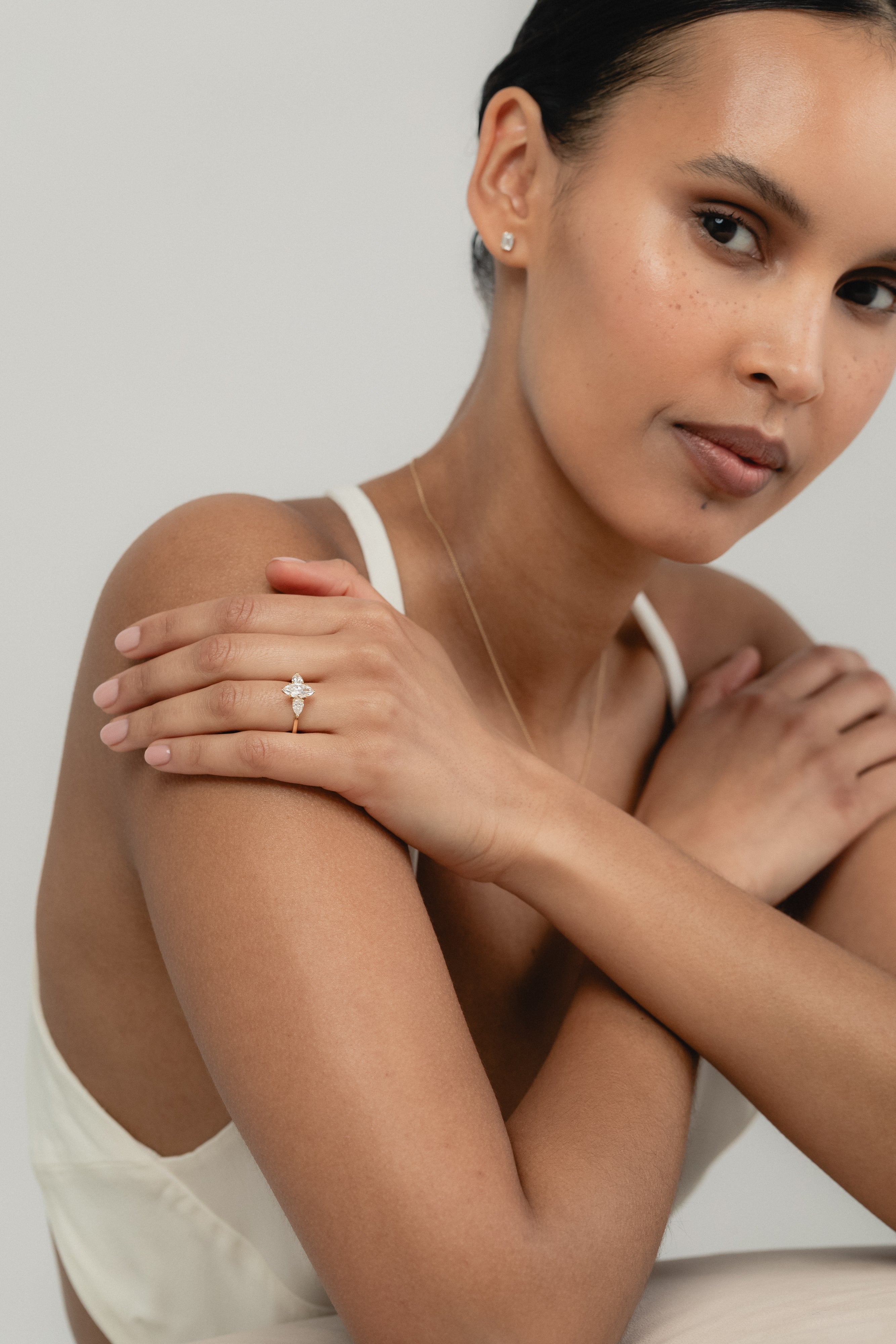 Close-up of the Marquise Trilogy three-stone lab-grown diamond engagement ring in yellow gold on a model's hand