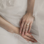 Bride wearing KARAAT Oval Solitaire diamond engagement ring in 18k white gold paired with a tulle wedding dress.