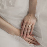 Bride wearing KARAAT Oval Solitaire diamond engagement ring in 18k yellow gold paired with a tulle wedding dress.