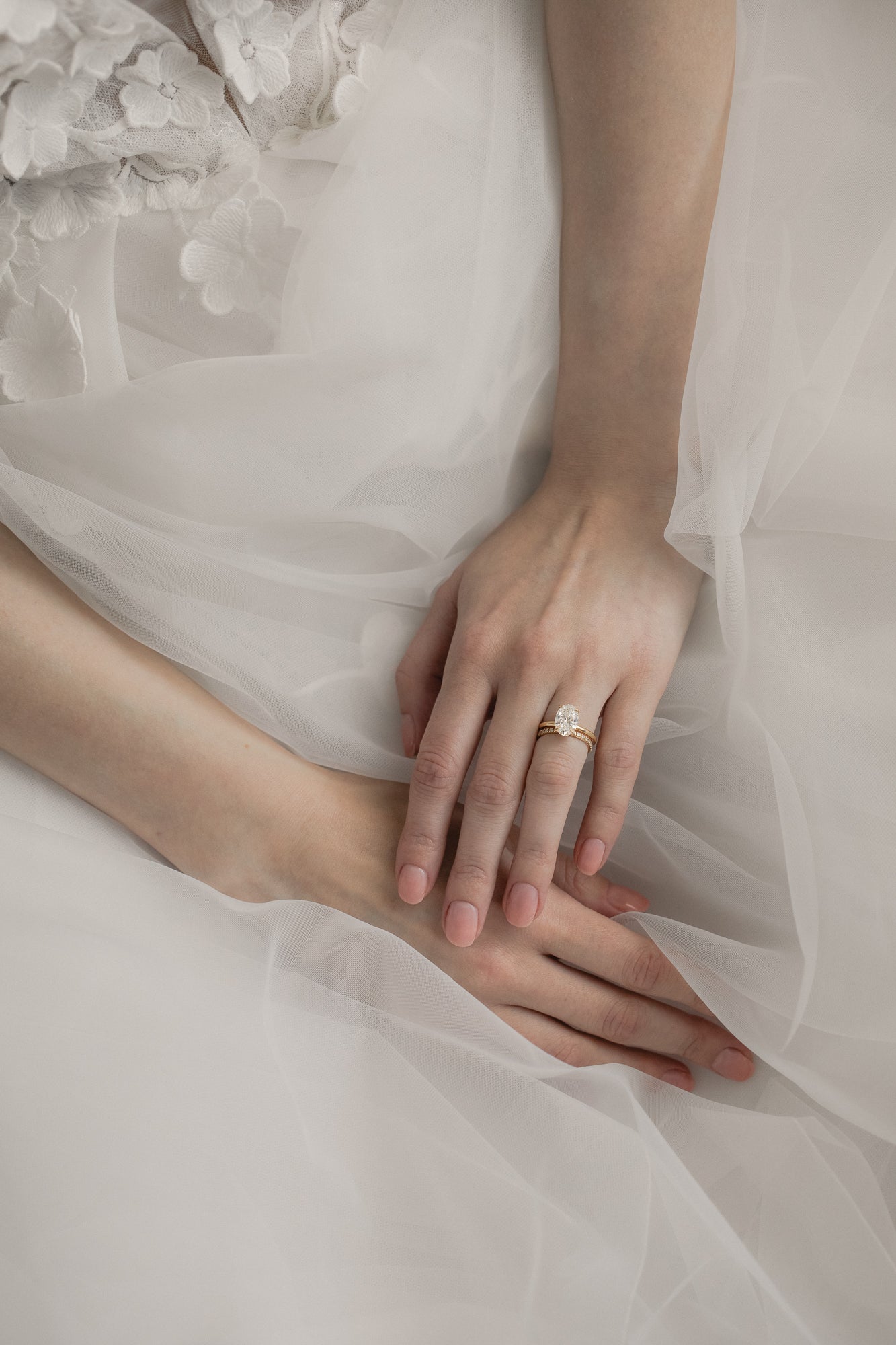 Bride wearing KARAAT Oval Solitaire diamond engagement ring in 18k rose gold paired with a tulle wedding dress.