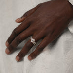 Model's hand wearing the KARAAT Oval Trilogy engagement ring in 18k yellow gold, showing the three-stone proportions.