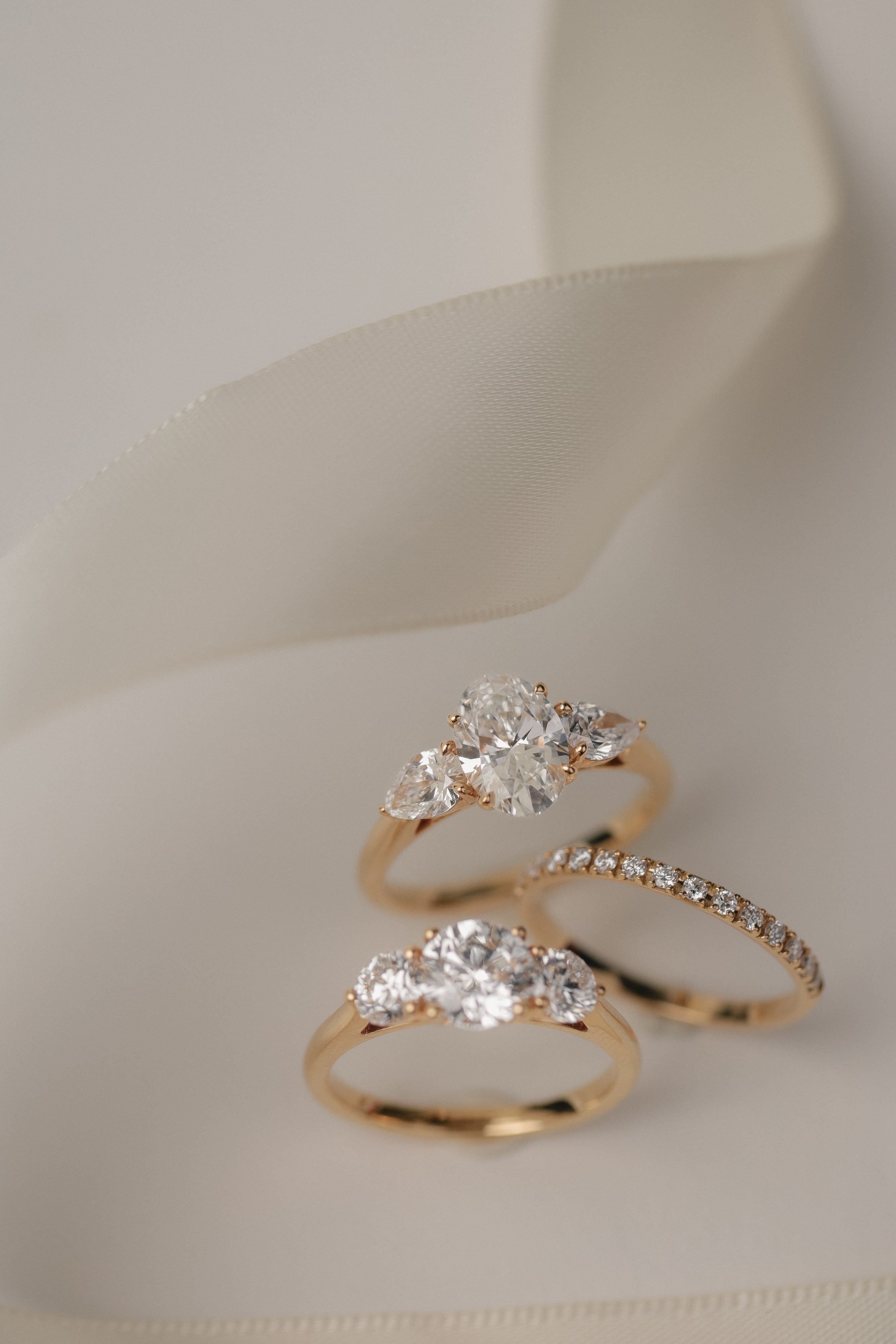 Product photography of the KARAAT Oval Trilogy in 18k white gold, detailing the precise three-stone setting.