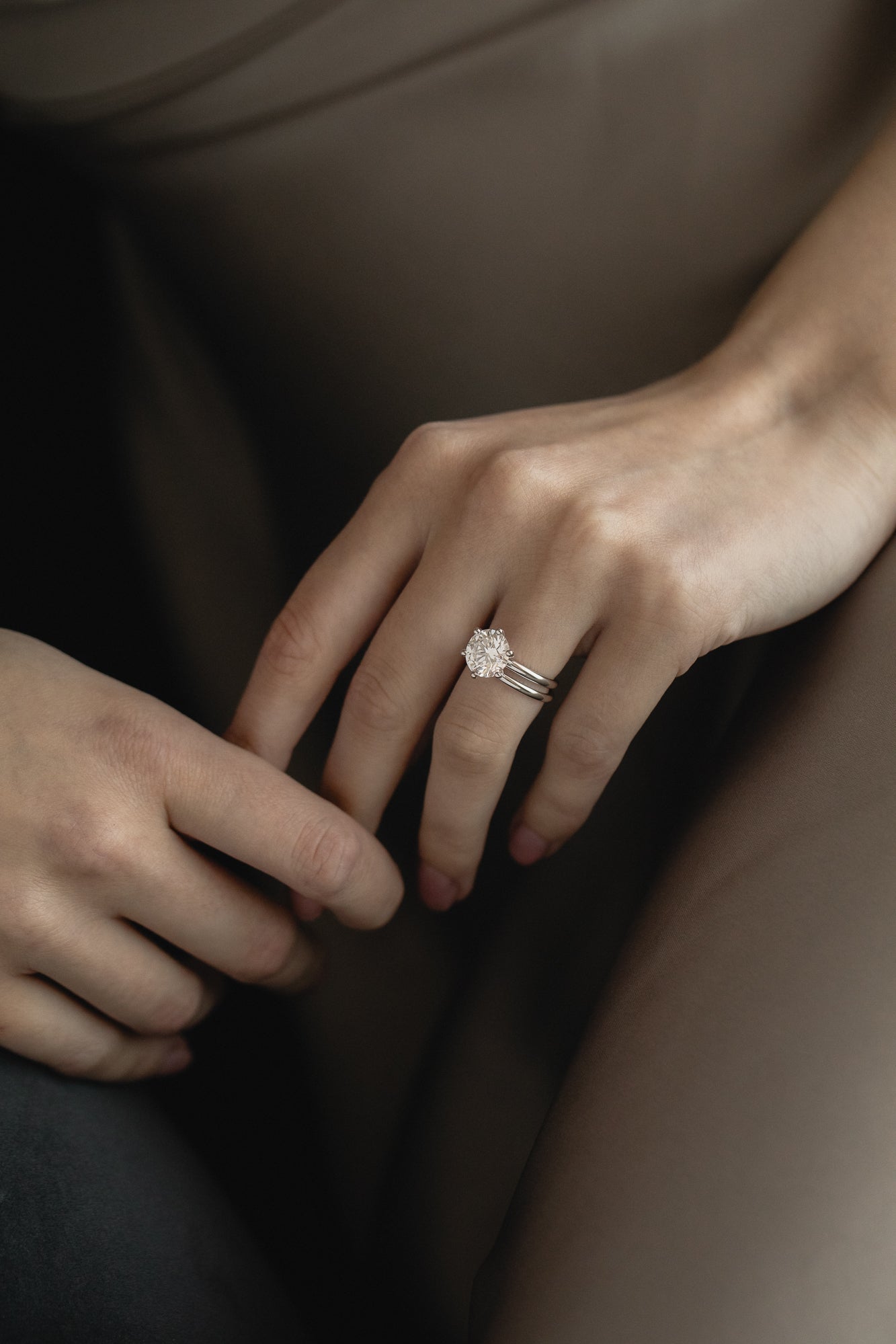 Close-up view of the KARAAT Round Six Prong Solitaire in 18k yellow gold on a model’s hand, showing the secure setting.