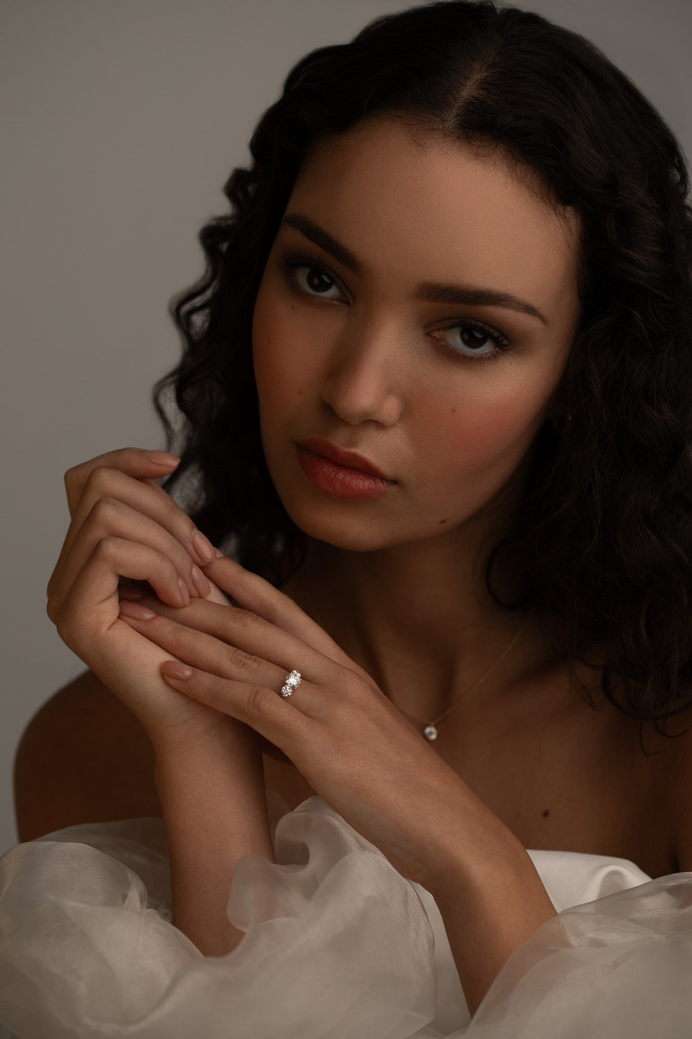 Romantic bridal styling with the KARAAT Round Trilogy three-stone diamond ring in 18k white gold.