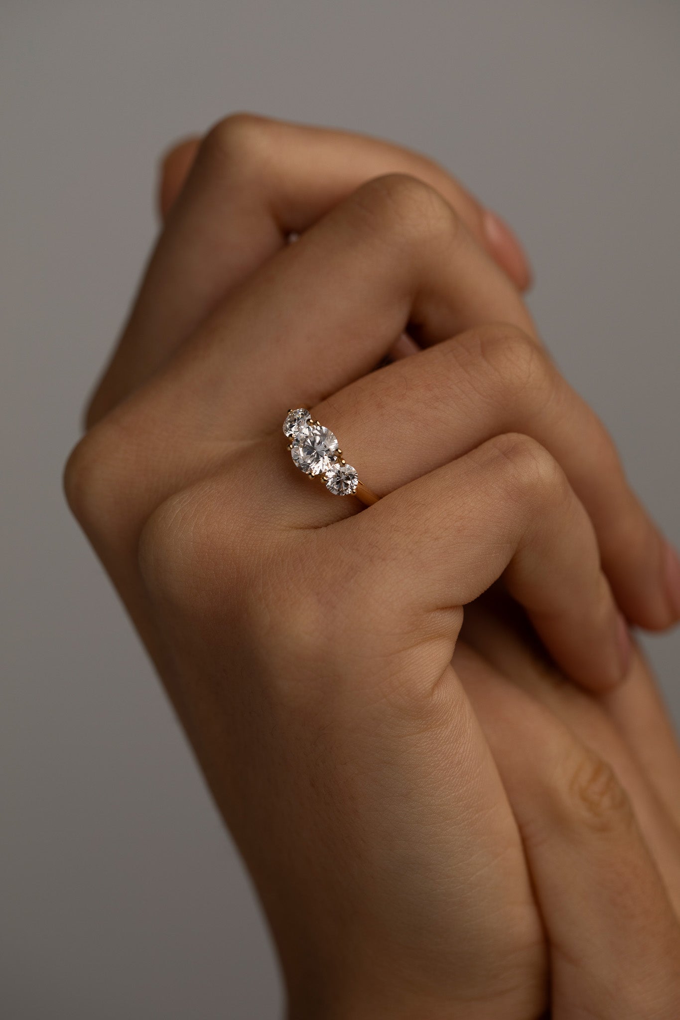 The KARAAT Round Trilogy engagement ring in 18k rose gold shown on a model, highlighting its brilliant sparkle.