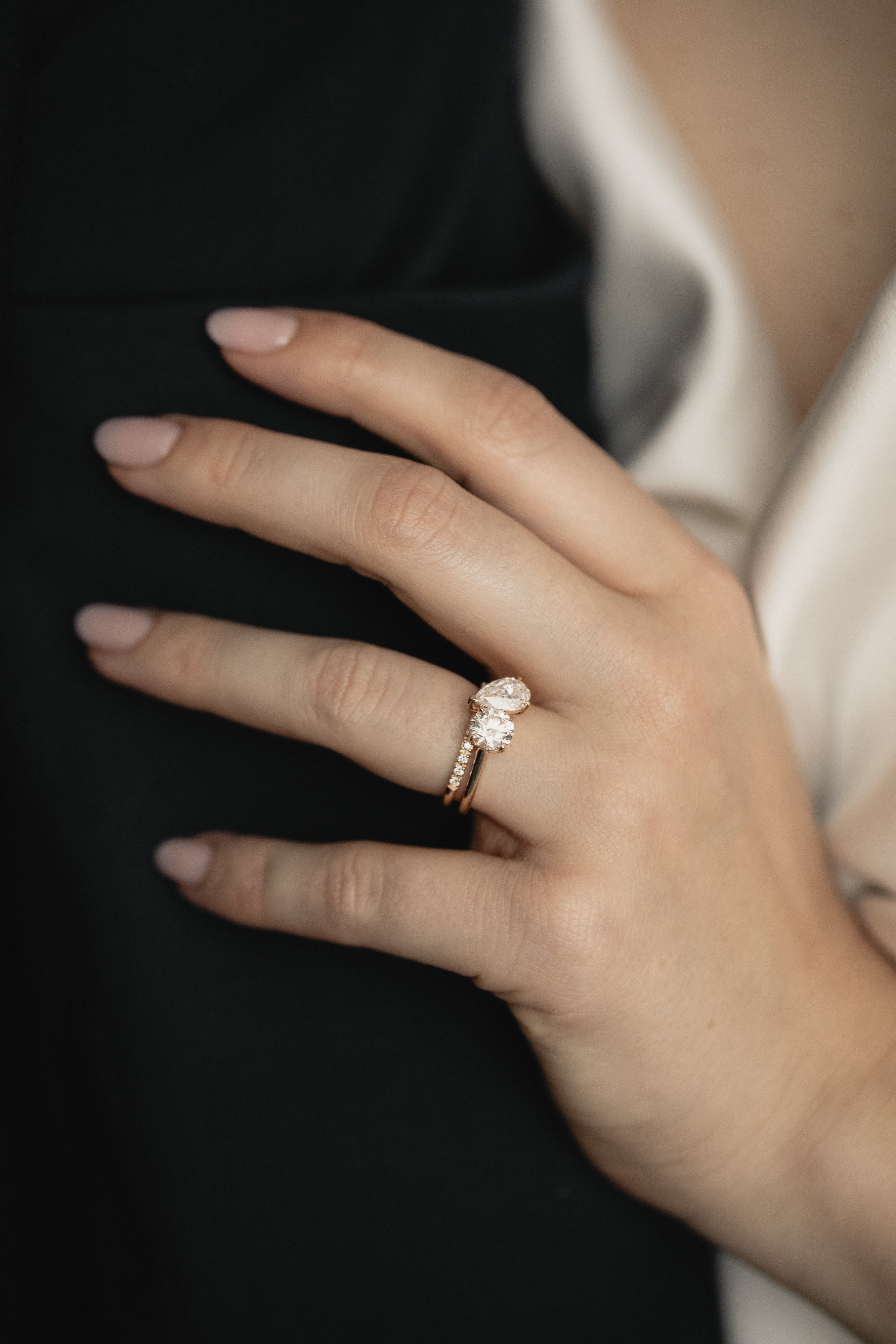 Round and Pear Toi et Moi engagement ring in yellow gold stacked with a pavé diamond wedding band